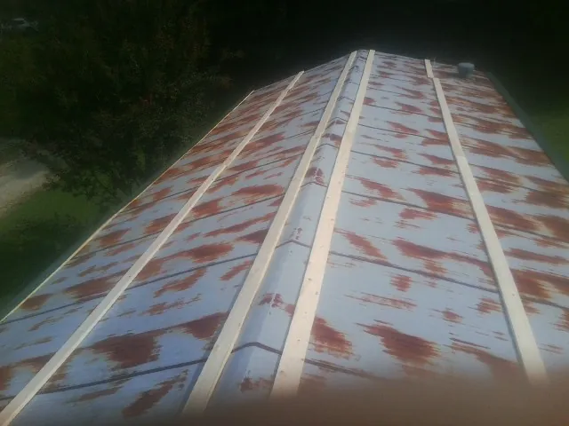 Rusted metal roof panels with new wood purlins before replacement — Storm Damage Roof Repair in Salinas by Roofing Brothers