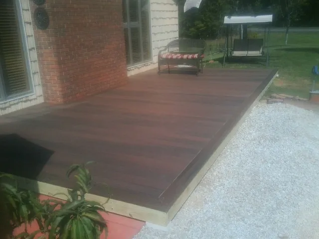Freshly stained wood deck built against a brick home in Salinas