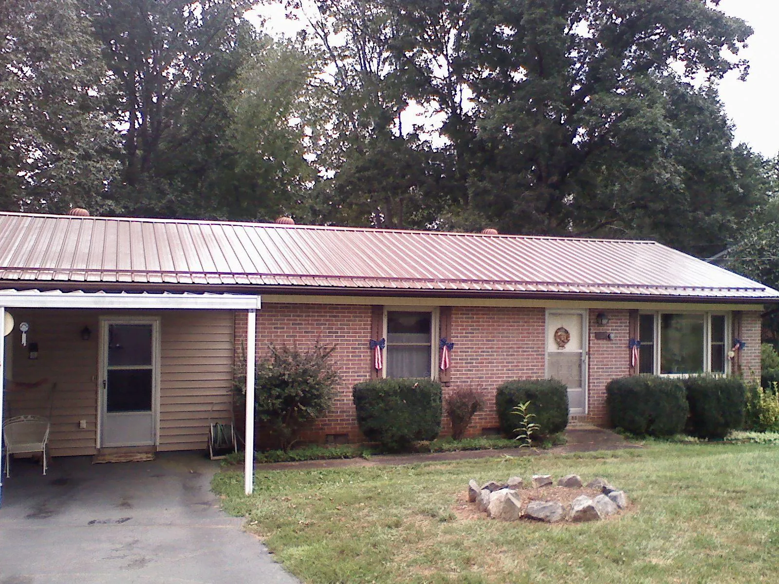 Bronze metal roof and carport on a brick ranch home — Roof Repair work by our crew in Salinas